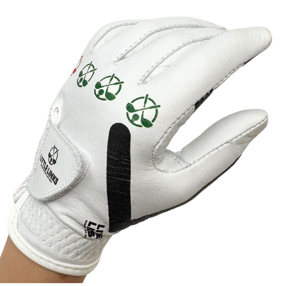 Little Links kids golf training glove for right hand in white shown in a back view on a child’s hand, highlighting the printed grip alignment icons, adjustable wrist closure, and durable stitching designed to help young golfers learn proper hand positioning and build confidence while playing.