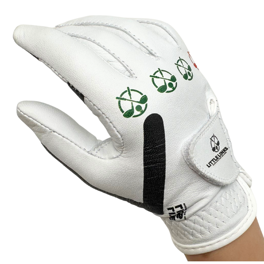 Little Links kids golf training glove for right hand in white shown in an angled view on a child’s hand, highlighting printed grip alignment icons, flexible material, and adjustable wrist closure designed to help young golfers develop proper hand positioning and build confidence while learning the game.